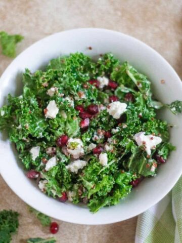 kale and quinoa salad with pomegranates goat cheese and and a delicious champagne dressing