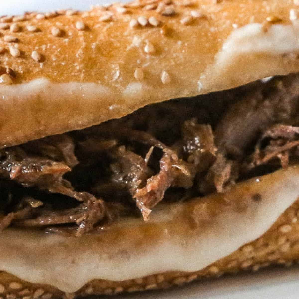 Warm french dip sandwich with melted provolone cheese and a tasty au jus dip