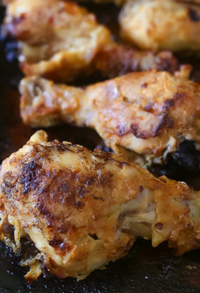 Side view of delicious buttermilk marinated chicken drumsticks on a baking sheet