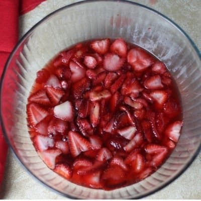 An overhead view of the topping of a strawberry pretzel dessert recipe made with jello and frozen strawberries