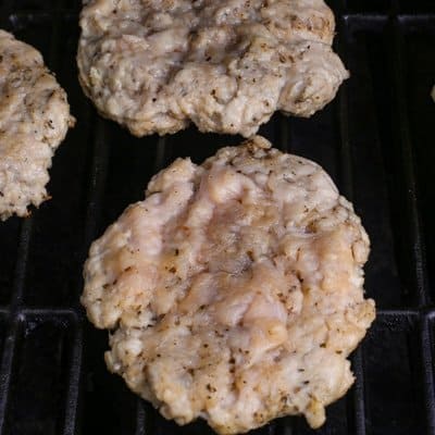 Parmesan Chicken burgers being grilled on the grill.