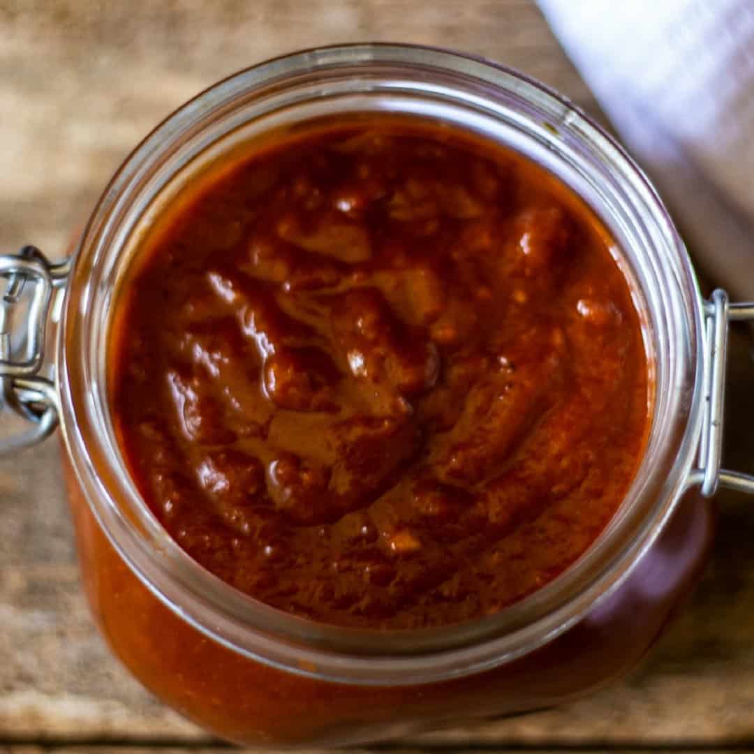 Tasty and spicy homemade chipotle BBQ sauce in a Ball Mason jar ready to slather all over a beef brisket.