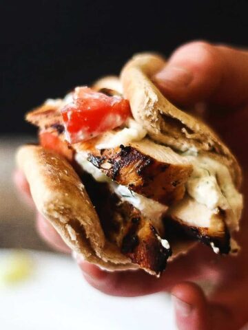 Grilled greek chicken gyros in a pita topped with cucumber, tzatziki and tomatoes.