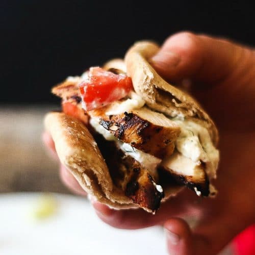 Grilled greek chicken gyros in a pita topped with cucumber, tzatziki and tomatoes.