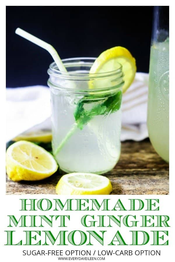 Homemade mint ginger lemonade in a mason jar filled with ice and mint with a yellow paper straw on a wooden table with fresh lemon slices on the sides of the jar.