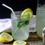 Thirst quenching mint ginger lemonade with mint and a lemon wedge on a wooden table ready to be served!