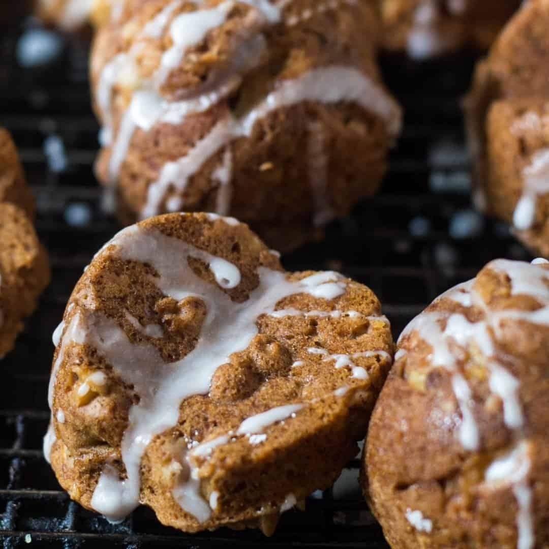 apple cakelets drizzled with maple cream on a cooling rack