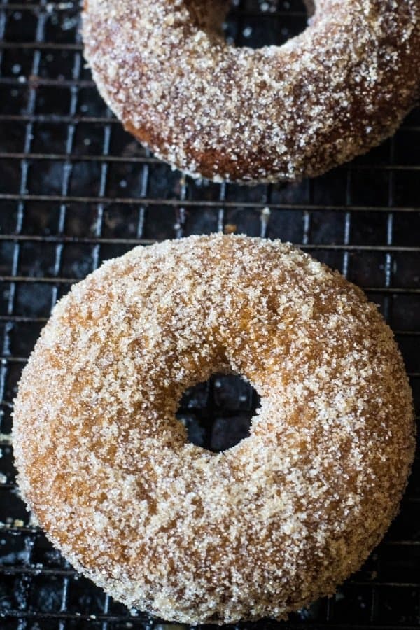 A Baked Apple Cider Donuts with Cinnamon Sugar cooling on a wire rack