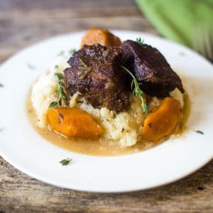 Delicious beer braised beef short ribs with carrots over mashed cauliflower