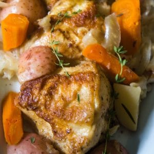 Hard cider braised chicken cabbage potatoes, fennel, apples, carrots on a platter.