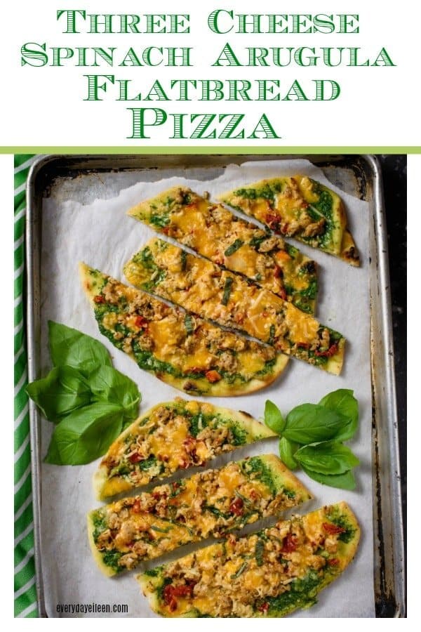 Three cheese spinach arugula flatbread pizza on a tray with fresh basil 