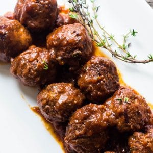 The most delicious crockpot cranberry meatballs that have been slow cooked and now served on a platter with a sweet and spicy sauce.