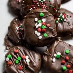 Homemade peppermint patties covered with delicious chocolate and sprinkled with Holiday Christmas sprinkles.