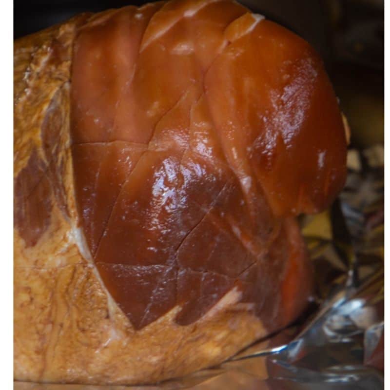 A smoked ham that has been scored and ready to be baked.