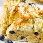 blueberry scones with fresh berries on a white plate.