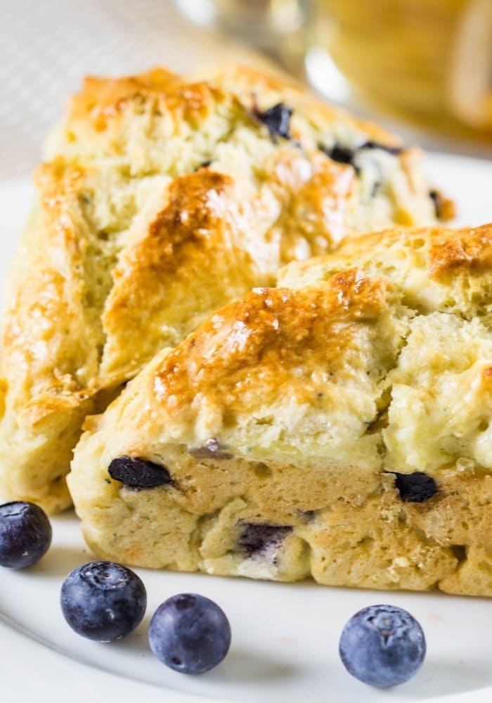 blueberry scones with fresh berries on a white plate.