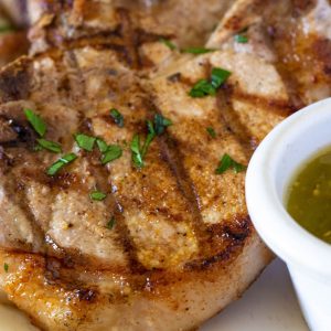 mexican pork chops with tomatillo salsa sprinkled with fresh parsley