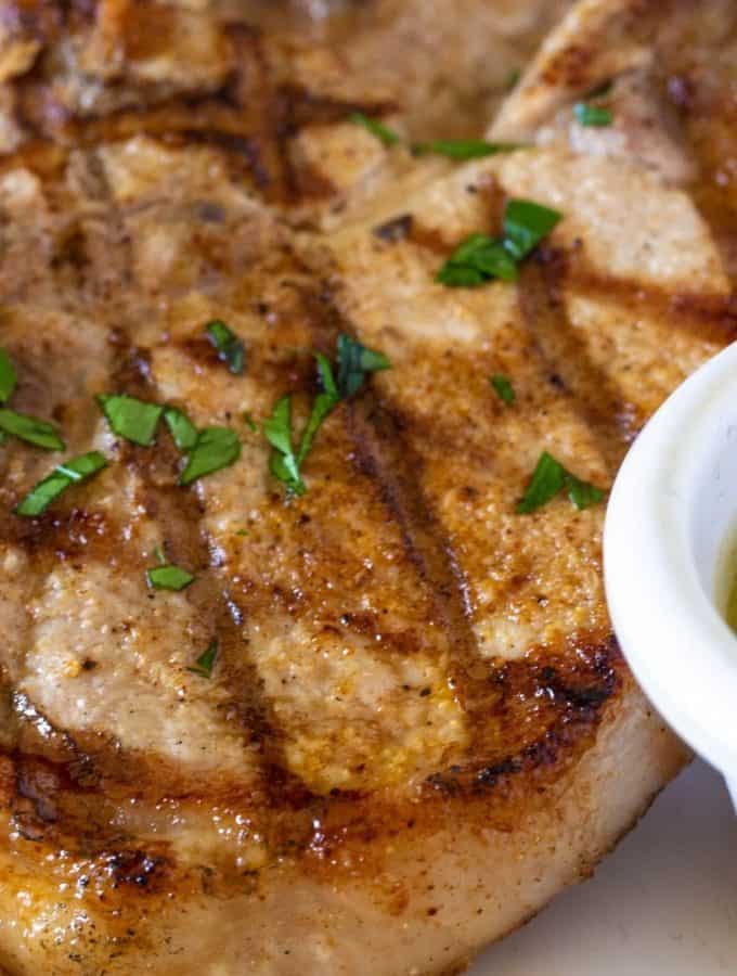mexican pork chops with tomatillo salsa sprinkled with fresh parsley