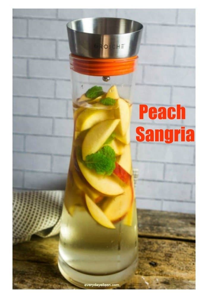 Peach Sangria in a Grosche Sangria pitcher filled with sangria and peaches.