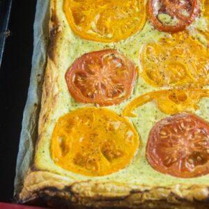 Cooked puff pastry topped with ricotta cheese and fresh tomatoes