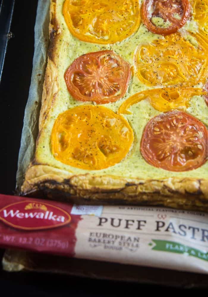 Ricotta tomato tart on a large baking sheet with the Wewalka puff pastry wrapper at the base of the pan.
