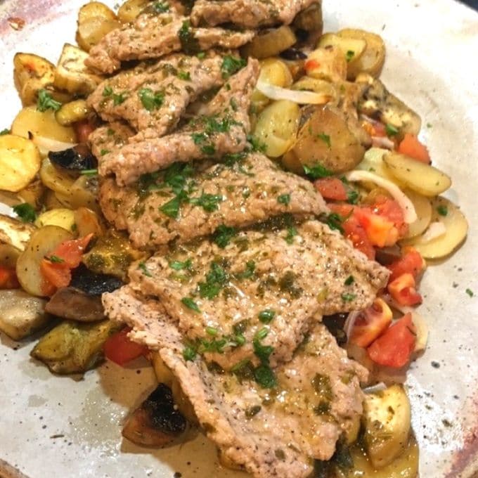 Sauteed veal cutlets with Mediterranean vegetables topped with a lemon wine sauce