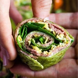 Roast beef tortilla rollups cut and being held in a hand