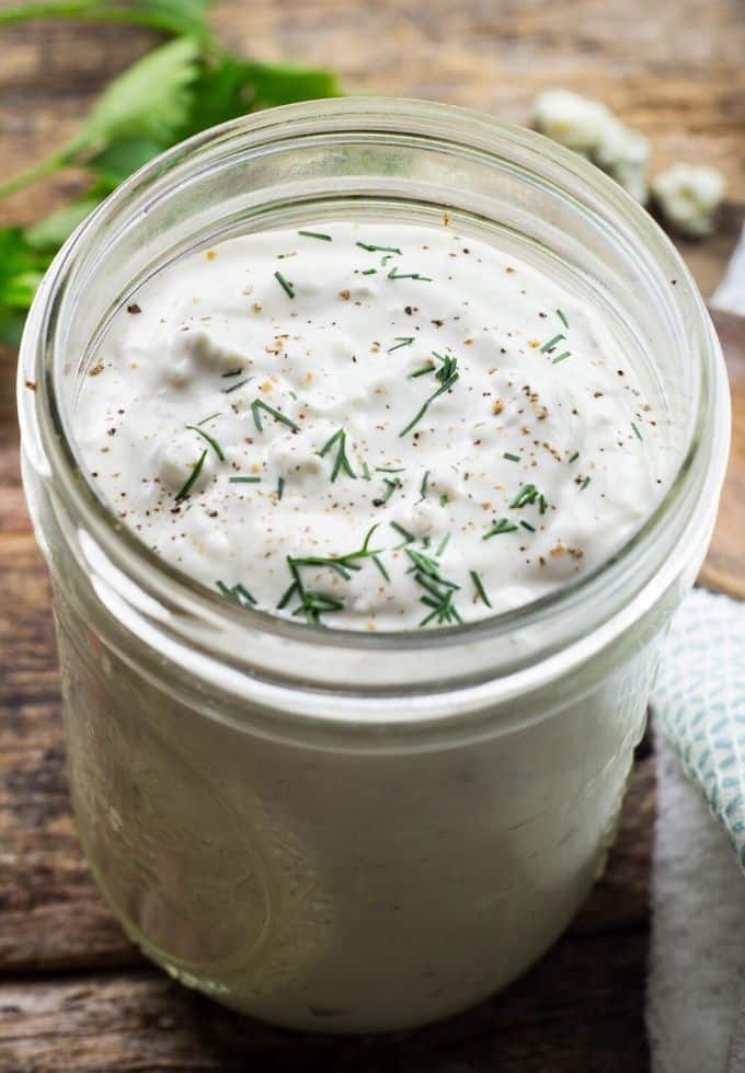 Homemade blue cheese salad dressing topped with fresh chives in a mason jar