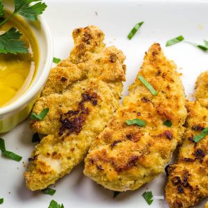 delicious chicken tender stacked on a white platter