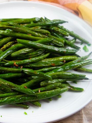 fresh oven roasted green beans on a white platter