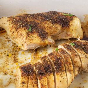 Sliced baked chicken in a baking pan