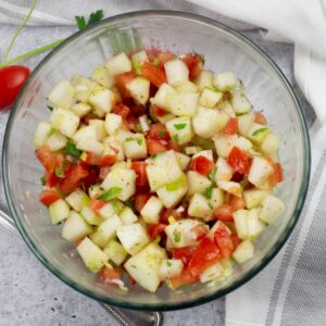 large bowl of diced cucumber and tomatoes with a vinaigrette