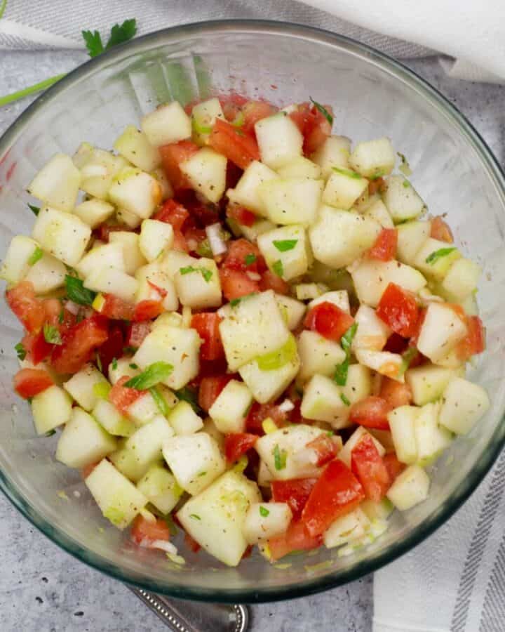 large bowl of diced cucumber and tomatoes with a vinaigrette