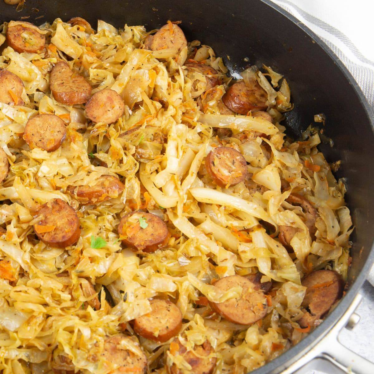 A large cast iron pan with sauteed cabbage and smoked cabbage