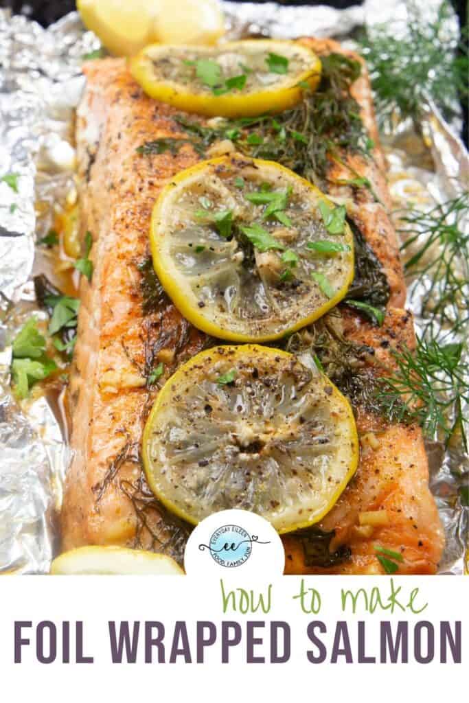 salmon on foil that has been grilled and topped with lemon and herbs