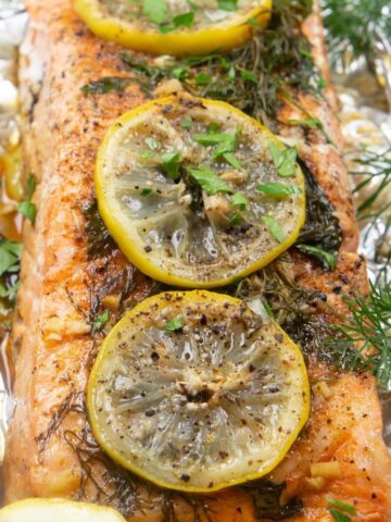 Grilled salmon topped with lemon and herbs, wrapped in foil and grilled.
