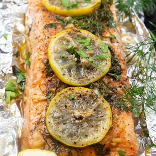 Grilled salmon topped with lemon and herbs, wrapped in foil and grilled.
