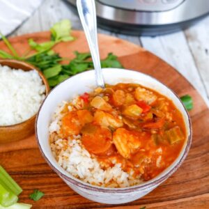 A bowl of rice topped with Creole style gumbo with a spoon in the bow.