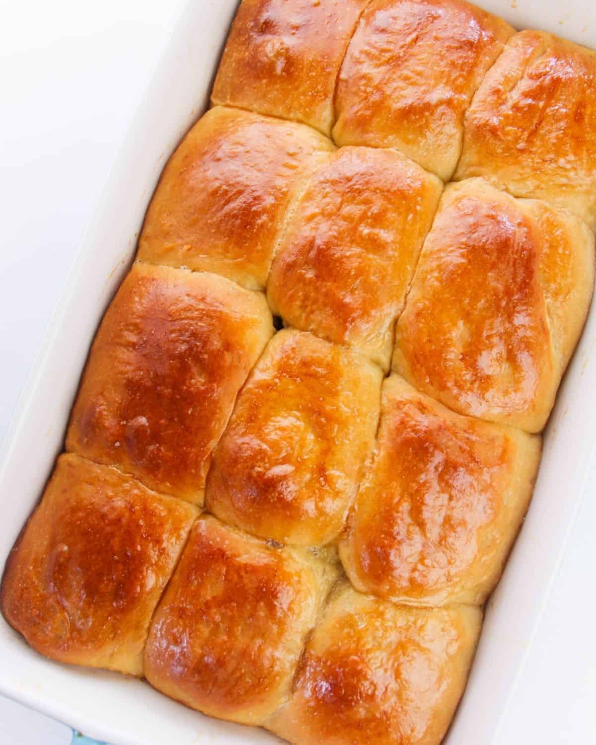 Baked Hawaiian sweet rolls in a white baking pan