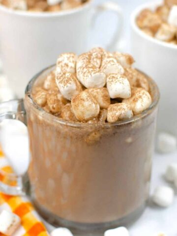 hot chocolate in a clear mug topped with marshmallows