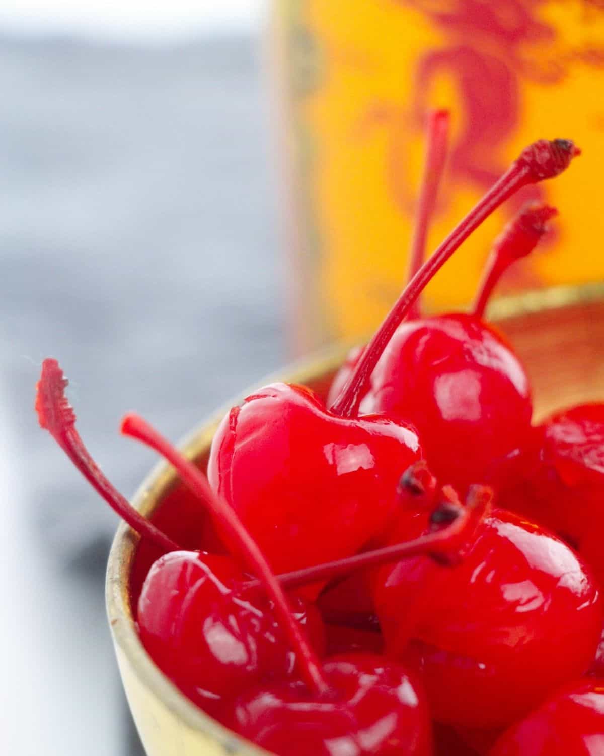 egy tál whisky infúzióban cseresznye előtt egy üveg fahéj whisky.