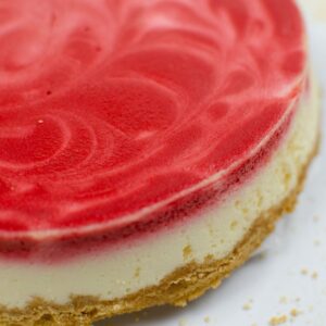 red velvet swirl cheesecake on a white plate.