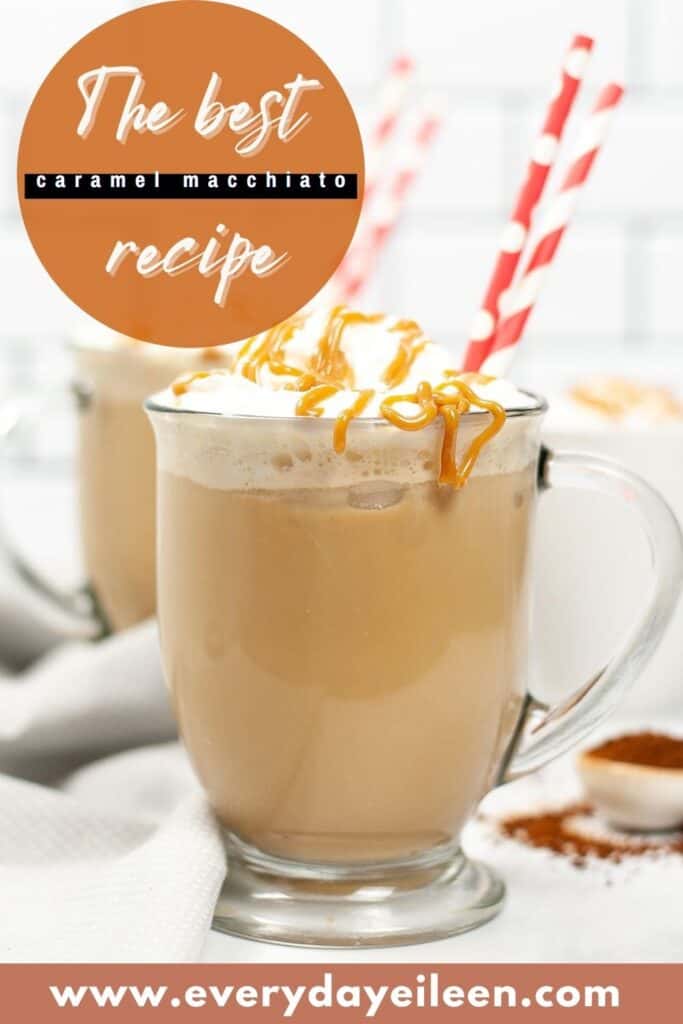 A glass mug with caramel macchiato topped with whipped cream, drizzled with caramel and two straws in the cup.