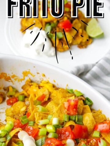 A white casserole dish with fritos, beans, sliced green onions