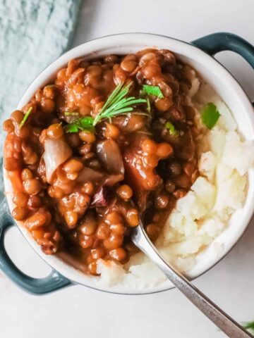 A vegetarian lentil soup over mashed potatoes.