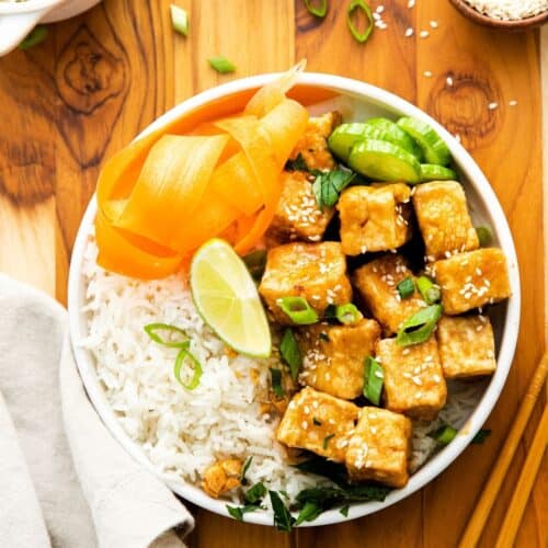 An overhead view of crispy tofu in and rice in a bowl.