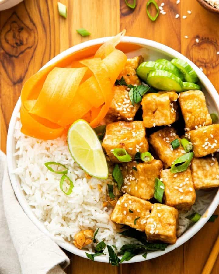 An overhead view of crispy tofu in and rice in a bowl.