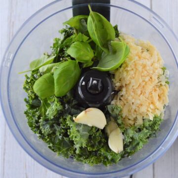 Basil, kale. garlic, oil, and Parmesan in a food processor.