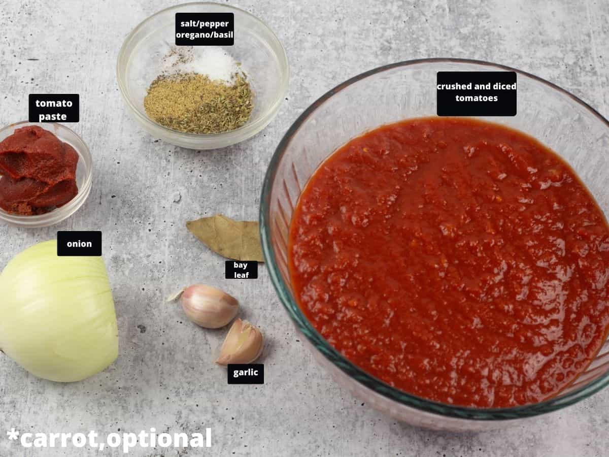The ingredients for marinara sauce on a grey table.