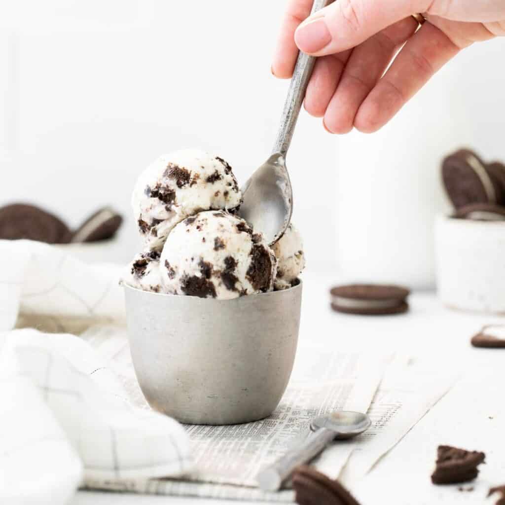 No-Churn Oreo Ic Cream in a bowl with crumbled chocolate cream cookies around the bowl.
